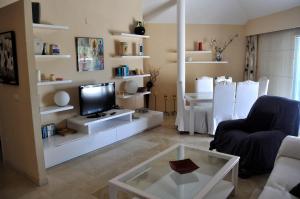 ein Wohnzimmer mit einem TV und einem Glastisch in der Unterkunft La Paz, ático, 2 dormitorios, Moreira, by Bookindenia in Moraira