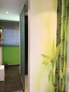 a hallway with a green wall and a plant at B&B Smile@life in Werchter