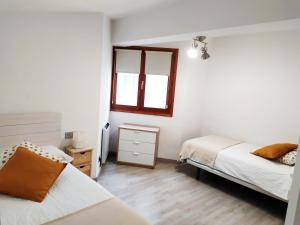 um quarto com 2 camas e uma janela em Adamar em Ribadesella