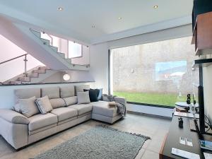 a living room with a couch and a large window at Villa North Sea by LovelyStay in Ponta Delgada