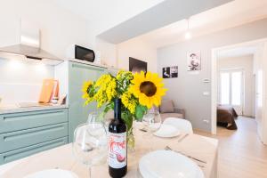 a kitchen with a table with a vase of yellow flowers at trifulhouse holiday apartments in Alba +65 photos