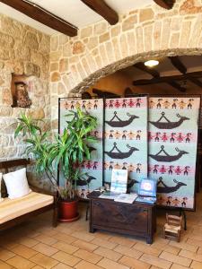 a room with a table and a wall with patterns at Hotel Bia Maore in Baunei