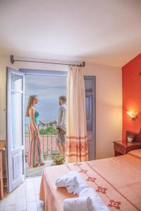 a hotel room with a woman standing on a balcony at Hotel Bia Maore in Baunei