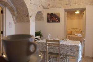 a kitchen and dining room with a table and chairs at TRULLI COLIBRI' in Locorotondo