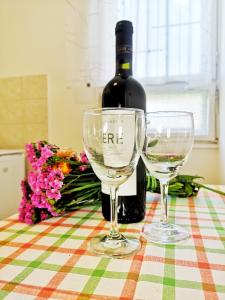 una botella de vino y dos copas de vino en una mesa en Arena Apartment, en Szombathely