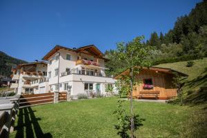 a large white building with a yard and a house at Apartment Valentina in Neustift im Stubaital
