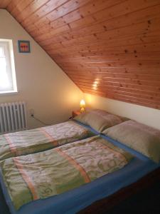 two beds in a bedroom with a wooden ceiling at Chata Kubko in Bobrovník