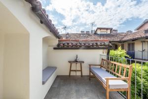 einen Balkon mit einer Bank und einem Tisch in der Unterkunft trifulhouse holiday apartments in Alba