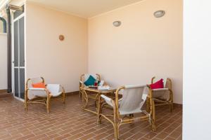 een wachtkamer met stoelen en een tafel bij Viona Apartments in Alghero