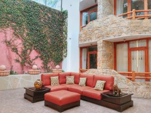 a red couch sitting in front of a building at Plaza Magnolias Suites in San Cristóbal de Las Casas