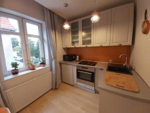 a kitchen with a stove and a sink and a window at LENGOWSKIEGO APARTAMENT CENTRUM in Olsztyn