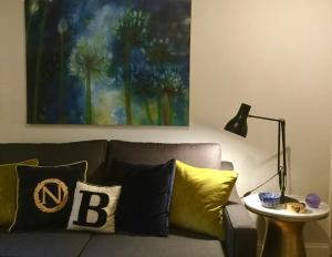 a living room with a couch with pillows and a lamp at Beautiful 1BR Apartment in Historic St Aubin House in Saint Aubin