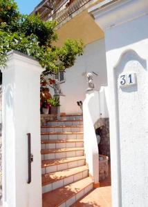 una escalera que conduce a una casa con un número en B&B Angelide, en Anacapri