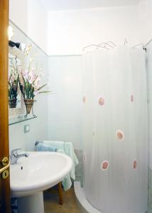 a white bathroom with a sink and a shower at B&B Angelide in Anacapri