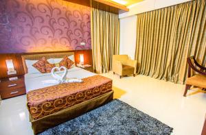 a hotel room with a bed and a chair at Hotel La Villa Western by Sea Pearl Beach Resort & Spa in Dhaka