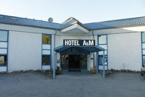 a hotel entrance with a sign that reads hotel amanu at A&M Hotel Barsinghausen in Bad Nenndorf