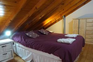 a bedroom with a purple bed in a attic at Departamentos Antu Cuyen in San Martín de los Andes