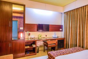 a hotel room with a bed and a desk at Hotel La Villa Western by Sea Pearl Beach Resort & Spa in Dhaka