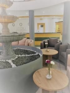 a lobby with a fountain and two tables and chairs at A&M Hotel Barsinghausen in Bad Nenndorf