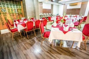 een eetkamer met tafels en rode stoelen bij Hotel La Villa Western by Sea Pearl Beach Resort & Spa in Dhaka
