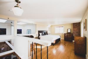 a white bedroom with a bed and a staircase at Swans Brewery, Pub & Hotel in Victoria