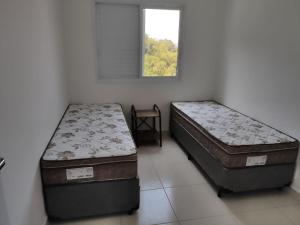 2 aparte bedden in een kamer met een raam bij AP Clube Lazer Total in Bertioga