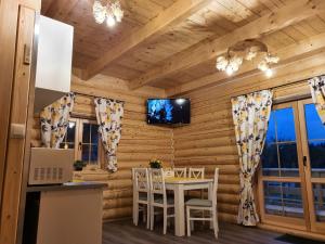 a dining room with a table in a log cabin at Cicha Polana in Szczyrk