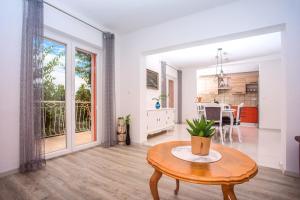 een witte woonkamer met een tafel en een keuken bij Villa Dawn in Trogir
