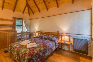 1 dormitorio con 1 cama con 2 toallas en Aldea Nevada en Ushuaia