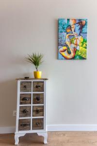 a chest of drawers with a painting on the wall at Ares ApartHotel in Cluj-Napoca