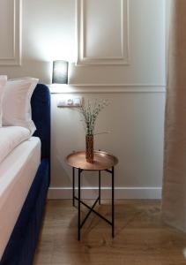 a table with a vase on it next to a bed at Ares ApartHotel in Cluj-Napoca