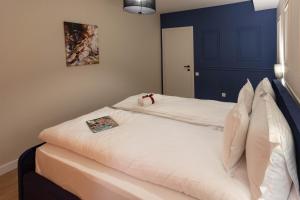 two white beds in a room with a blue wall at Ares ApartHotel in Cluj-Napoca