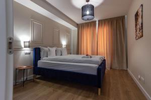 um quarto com uma cama grande e uma janela em Ares ApartHotel em Cluj-Napoca