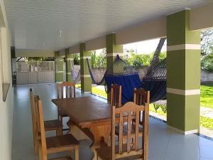 uma sala de jantar com uma mesa de madeira e cadeiras em Flamboyant em Bonito