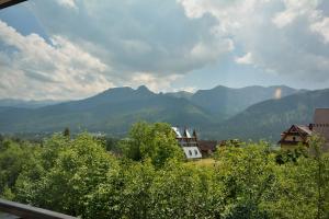- une vue sur une chaîne de montagnes avec des maisons et des arbres dans l'établissement Willa Ewka, à Kościelisko