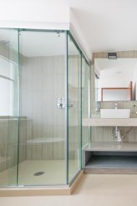 une douche en verre dans une salle de bain avec un lavabo dans l'établissement Deluxe Loft at Colonia ROMA, à Mexico