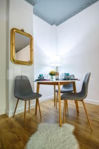a dining room table with two chairs and a mirror at Flamingos Apartment ★ Free Parking ★ City Center ★ in Novi Sad +37 photos
