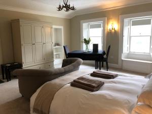 a bedroom with a bed and a couch and a table at Branxholme Castle (Bed & Breakfast) in Hawick