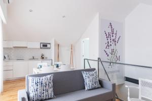 a living room with a couch and a kitchen at Botica Guesthouse in Espinho
