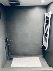 a bathroom with a shower with a towel on the floor at REM House in Thessaloniki