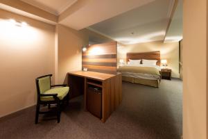 Una habitación de hotel con una cama, un escritorio y una silla. en Daria Suite, en Târgu Jiu 28 fotos más