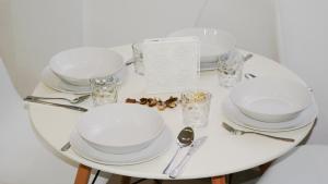 un tavolo bianco con piatti e argenteria di Apartamento El Andén de la Estación a Málaga