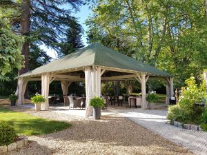 un cenador con mesas y sillas en un parque en Château de Lalande - Teritoria - Périgueux en Annesse-et-Beaulieu
