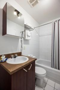 
a bathroom with a toilet, sink, and bathtub at Hotel Abri du Voyageur in Montreal

