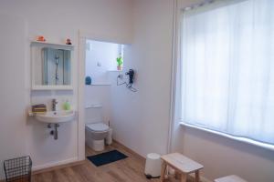 a bathroom with a sink and a toilet and a window at The garden flat in Luxembourg