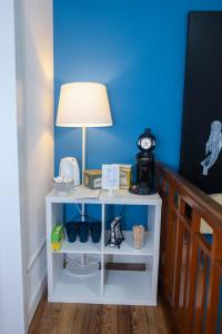 a white table with a lamp and a blue wall at The red house in Luxembourg