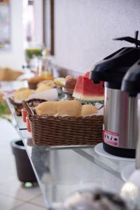 a buffet line with baskets of bread and watermelon at Hotel Vila Real Dourados in Dourados