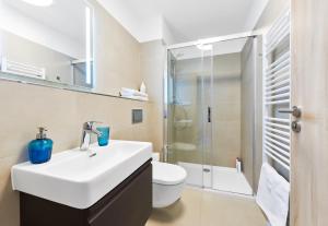 a bathroom with a sink and a toilet and a shower at Kvilda Apartments in Kvilda