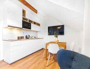 a kitchen with a table and a blue chair at Kvilda Apartments in Kvilda
