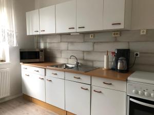 a kitchen with white cabinets and a sink at Misha,s Place in Duisburg
